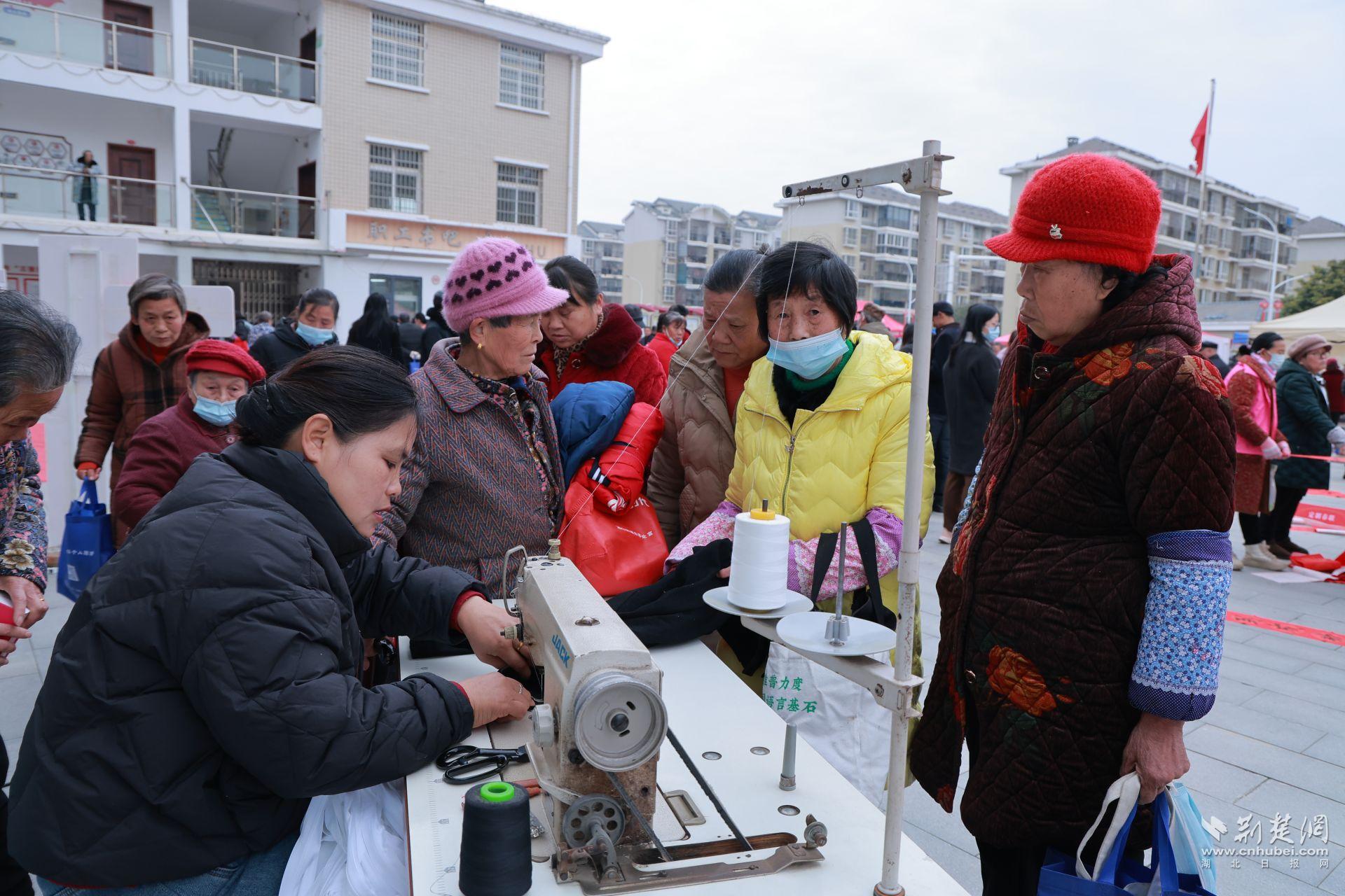 衣物縫補(bǔ)攤前，志愿者飛針走線為居民修補(bǔ)破損衣物.jpg.jpg